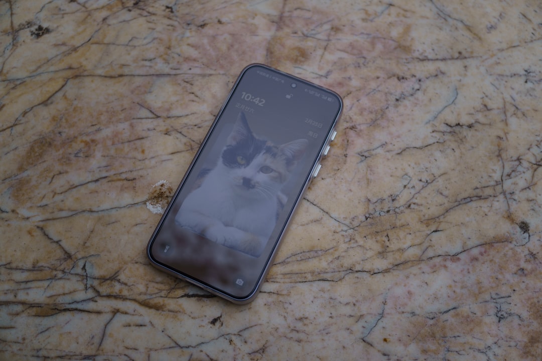 A phone with a cat wallpaper on marble.