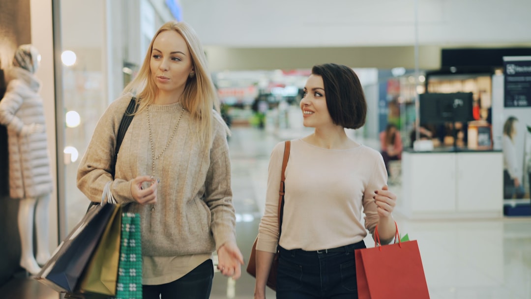 Two women shopping in a bright, modern mall.