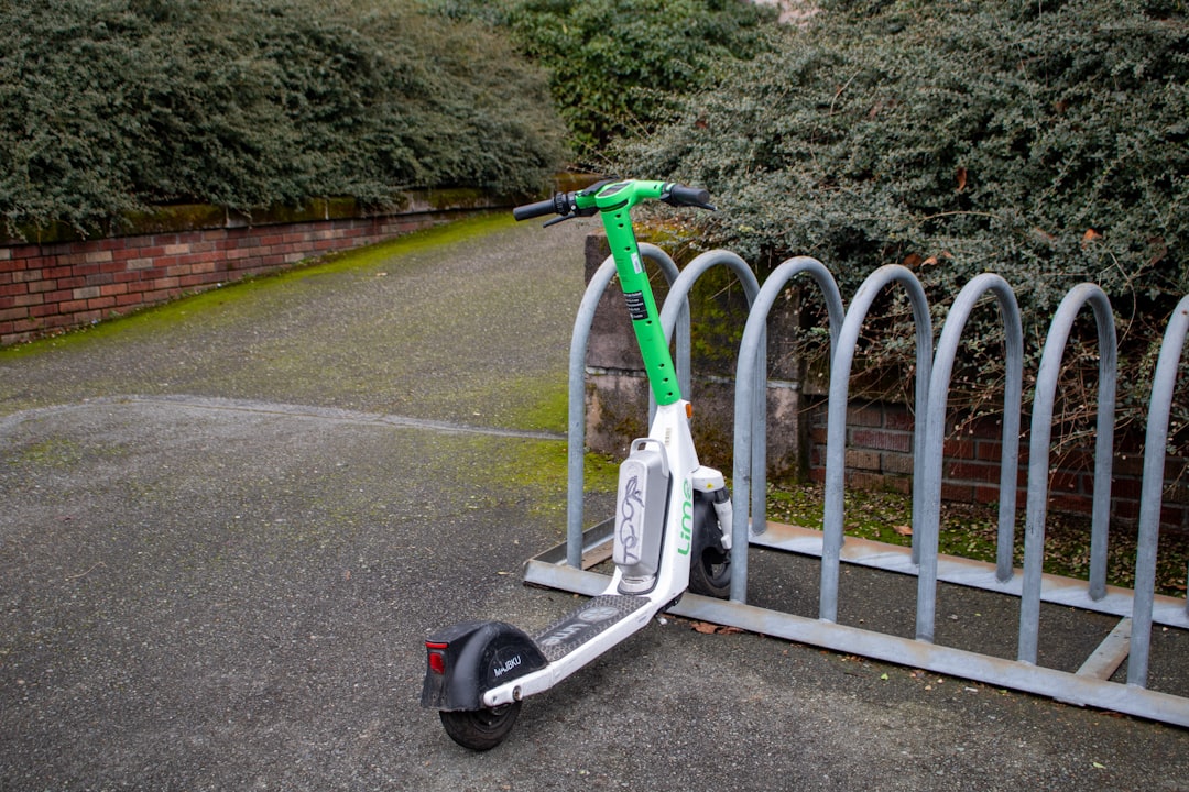 A lime scooter is parked in a rack.