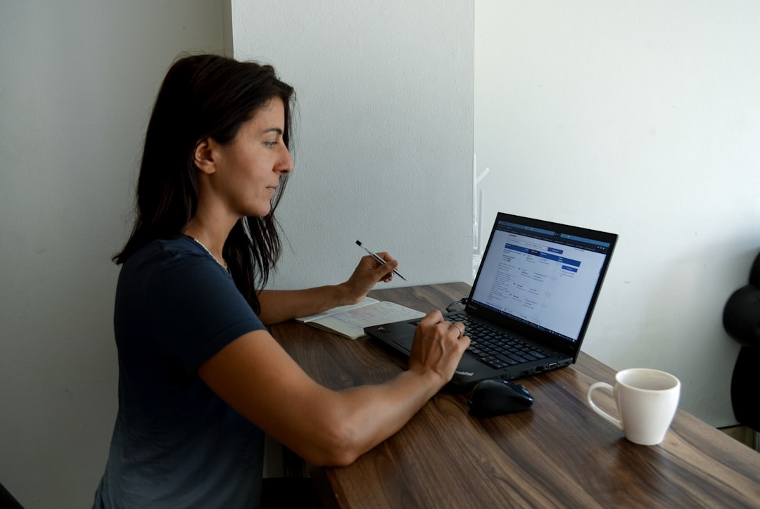 a woman sitting at a table with a laptop