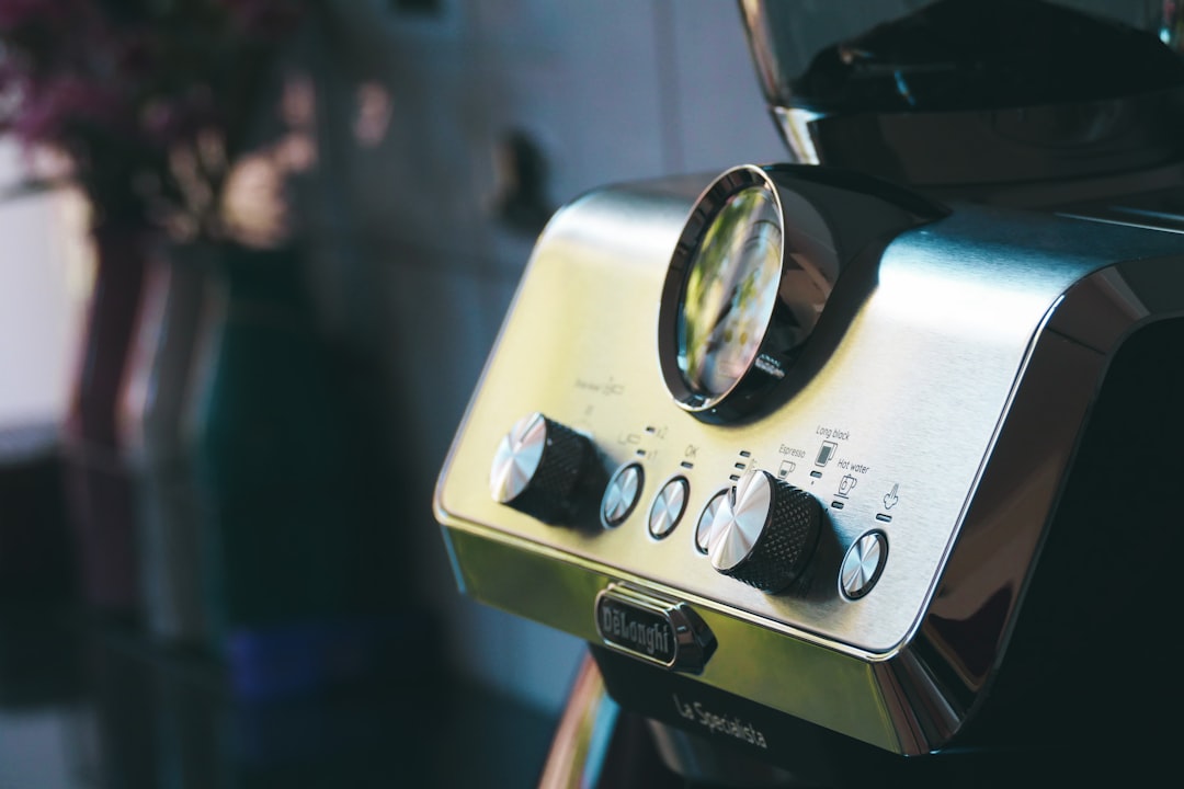a close up of a toaster oven with a flower in the background