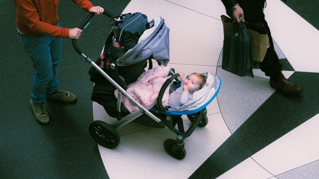 Parent pushing a baby in a stroller indoors