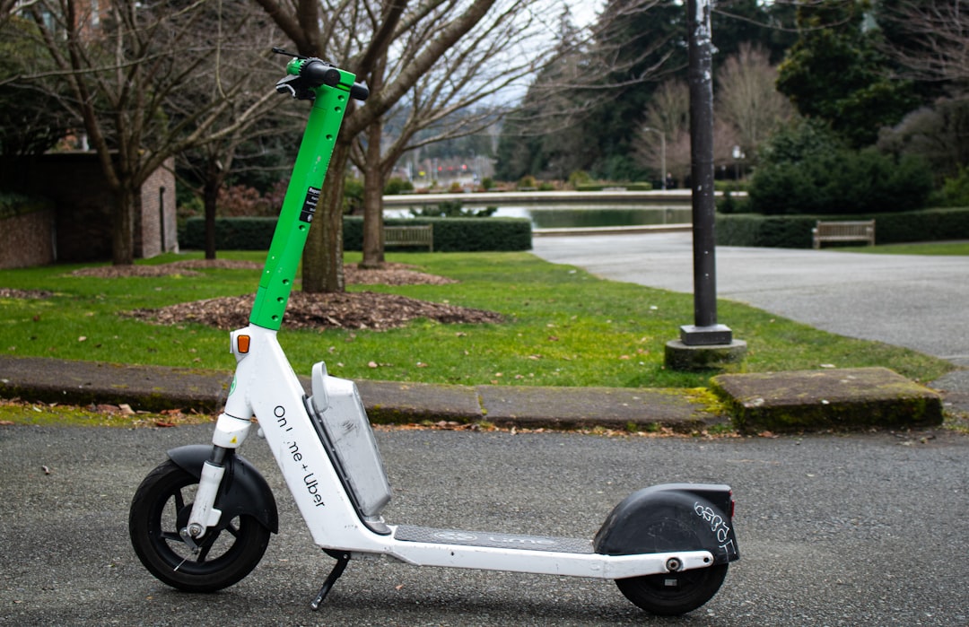 A lime scooter sits on a wet, paved surface.
